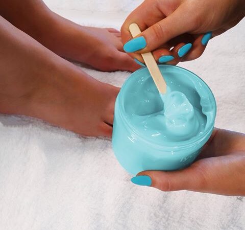 A professional therapist at Beauty by Ruth applying a soothing post-treatment lotion to a client’s leg to minimise common Waxing Side Effects like redness.